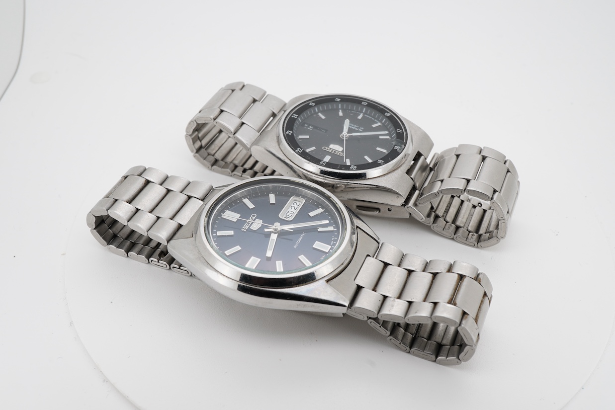 Two gentleman's recent stainless steel Seiko 5 automatic day/date wrist watches, one with black dial, the other blue dial, case diameters 36mm, both on stainless steel Seiko straps (one a.f.). no boxes or paperwork.